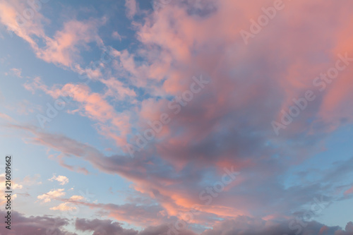 Fototapeta Naklejka Na Ścianę i Meble -  Beautiful clouds and blue sky background at sunset with pink and purple tones over England UK. Cloudscape and skyscape backdrop 0162