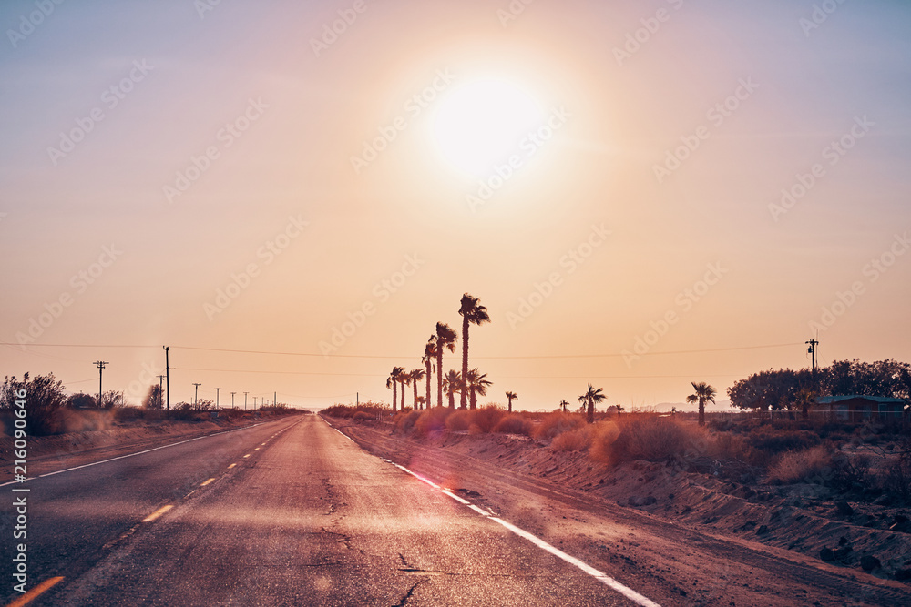 Empty road against the sun, color toned picture, travel concept, USA. Empty road against the sun, color toned picture, travel concept, USA.