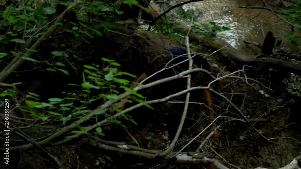 Tourist walks at the deep of jungle near wild yellow river Tourist walks at the deep of jungle near wild yellow river