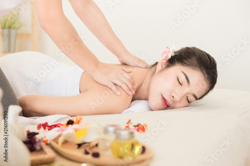 Young asian woman enjoying relaxing back massage in spa. Body care, skin care, wellness, alternative medicine and relaxation Concept.