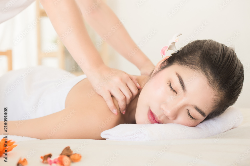 Young asian woman enjoying relaxing back massage in spa. Body care, skin care, wellness, alternative medicine and relaxation Concept. Young asian woman enjoying relaxing back massage in spa. Body care, skin care, wellness, alternative medicine and relaxation Concept.