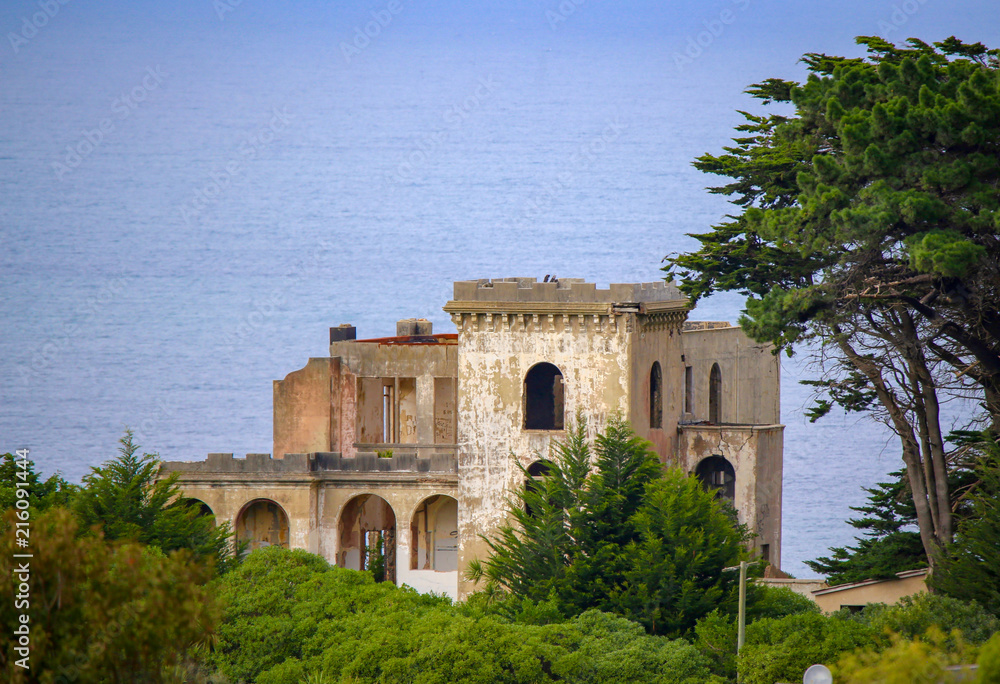 Fototapeta premium An old derelict castle sits high on a hill top overlooking the sea