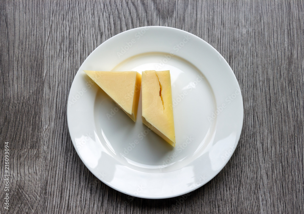Cheese on the plate against a wooden background Cheese on the plate against a wooden background