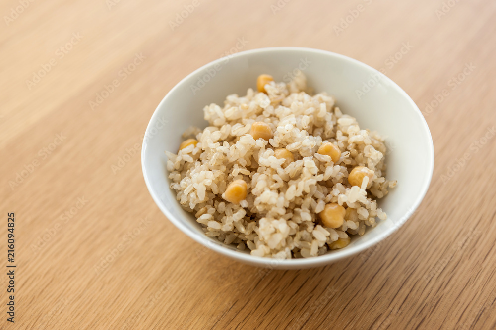 brown rice on the bowl, wood table. brown rice on the bowl, wood table.