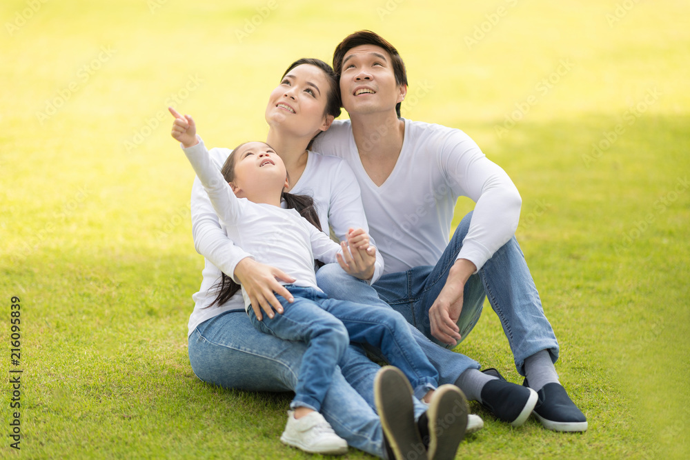 Family sitting on grass together.Young parent with little girl have playing for fun in nature outside. Family sitting on grass together.Young parent with little girl have playing for fun in nature outside.