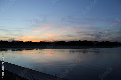 Fototapeta Naklejka Na Ścianę i Meble -  Sunset over ducks swimming on depleted reservoir