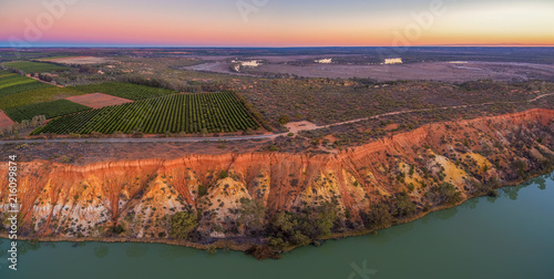 Orange sandstone erosion layers and agricultural fields at Murtho, Riverland, Australia at dusk - aerial panorama photo