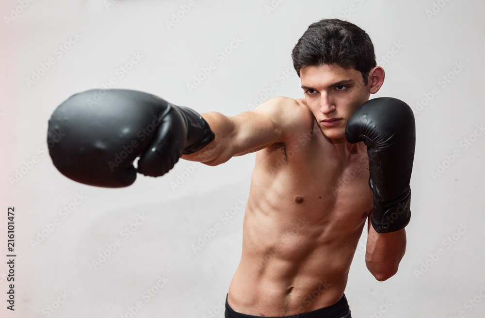 Giovane uomo si allena in palestra con guantoni da box