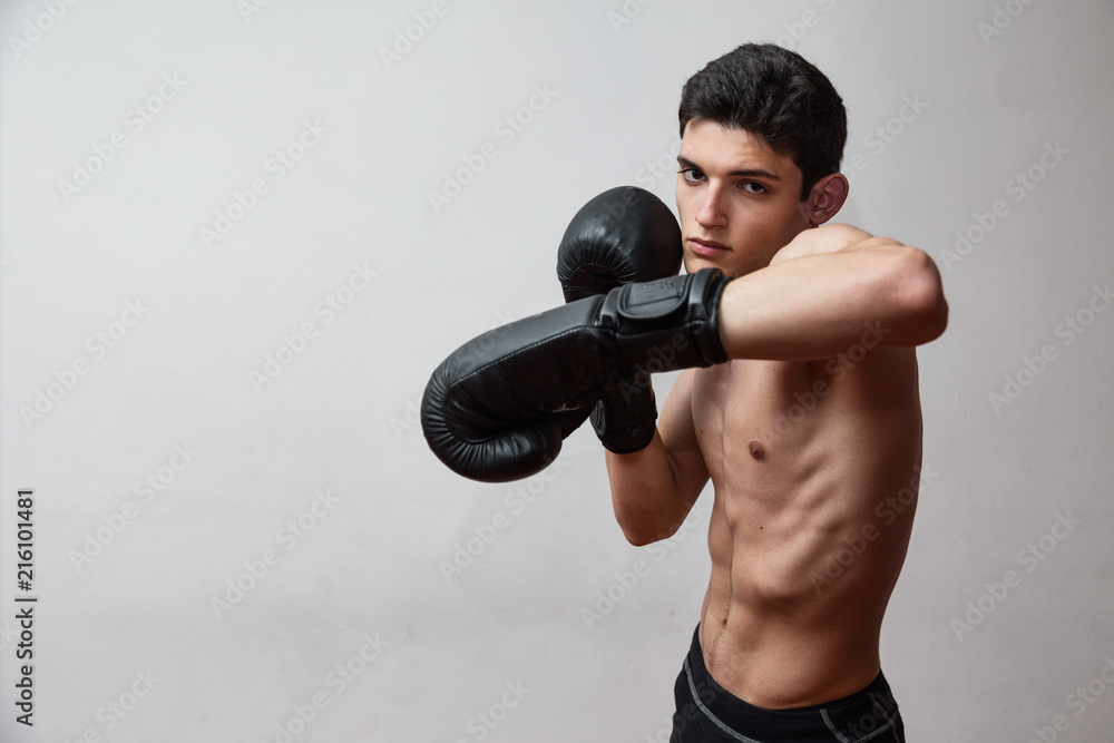 Giovane uomo si allena in palestra con guantoni da box