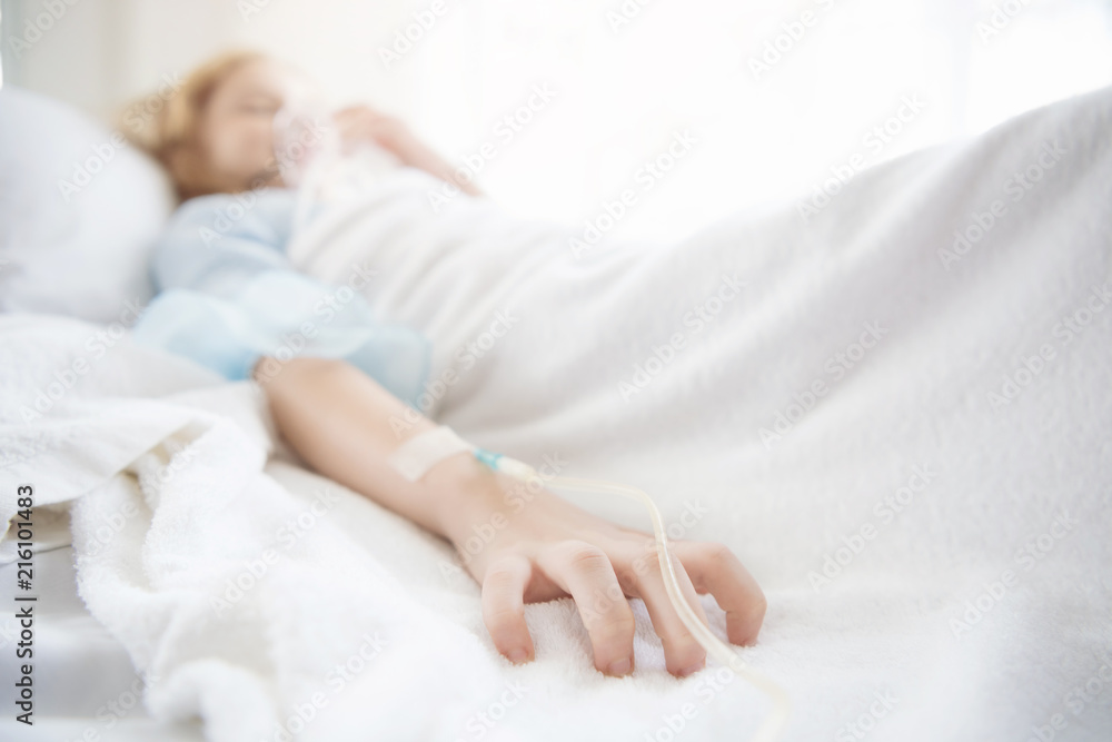 close up of saline on hand of sick girl lying on bed at hospital. Selective focus at finger. close up of saline on hand of sick girl lying on bed at hospital. Selective focus at finger.