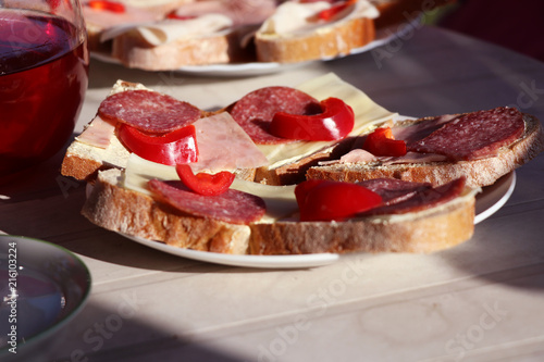 A casual snack in czech republic in Moravia part. Bread with ham, cheese, butter and red pepper on plate with fruit tea