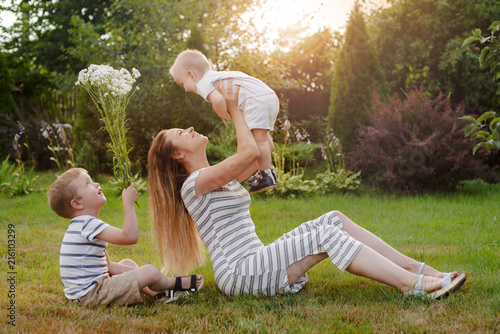 Mom, two children are resting in nature. Sibling rivalry. Brothers, younger son. Motherhood. photo