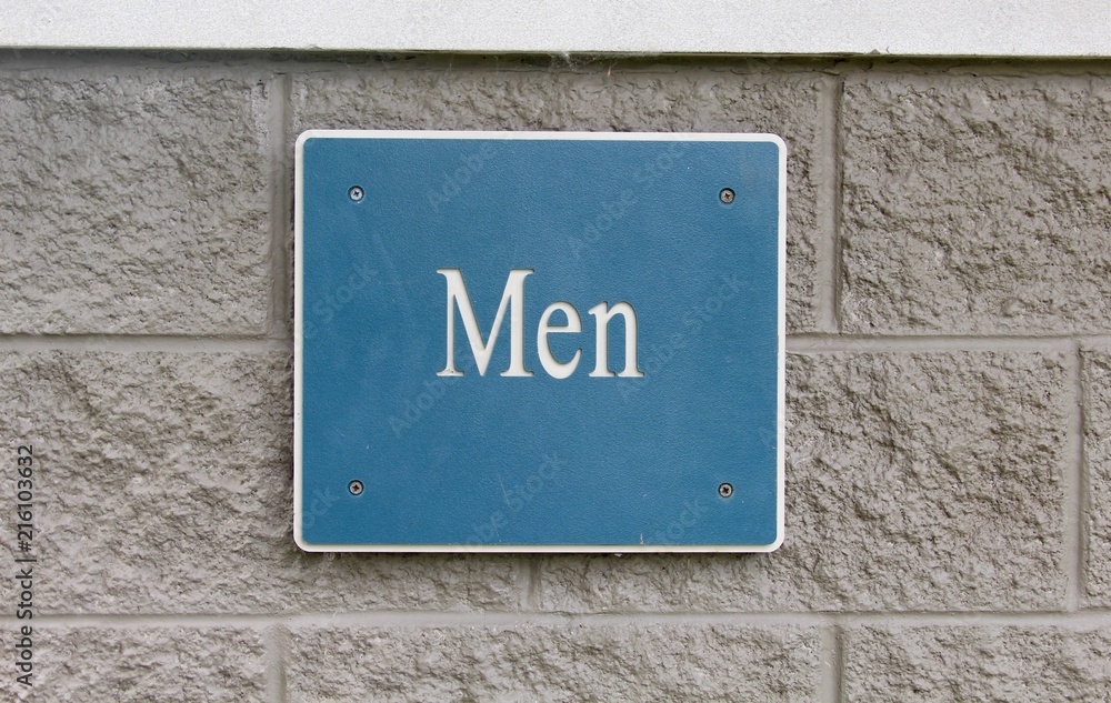 A men restroom sign on the brick wall and a close view.