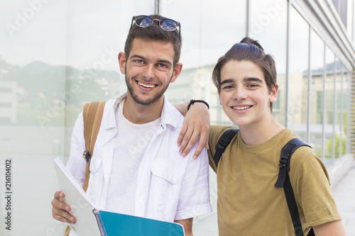 young students with books and notebooks on campus or college © carballo