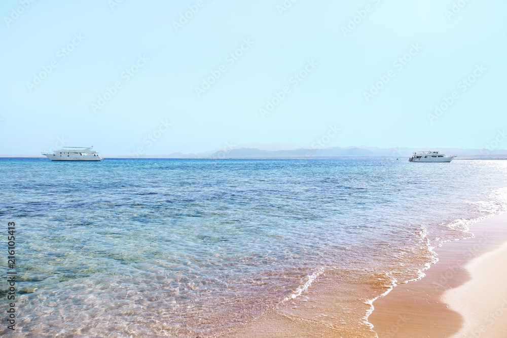 Beautiful view of blue sea with white yachts on sunny summer day