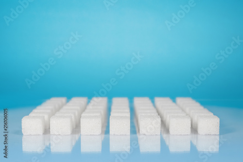 Table top shot Group of Sugar cubes vary position on light blue background