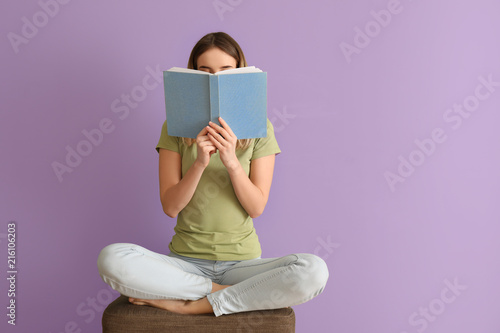 Young woman reading book ne...