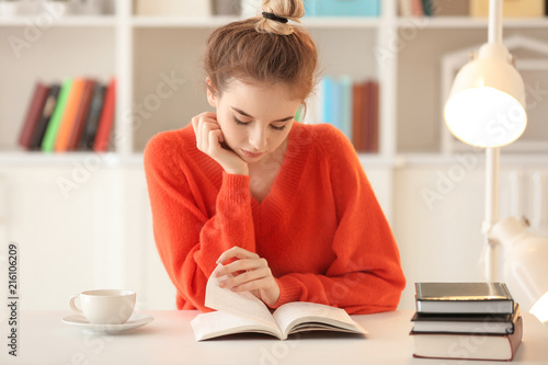 Young woman reading book at...