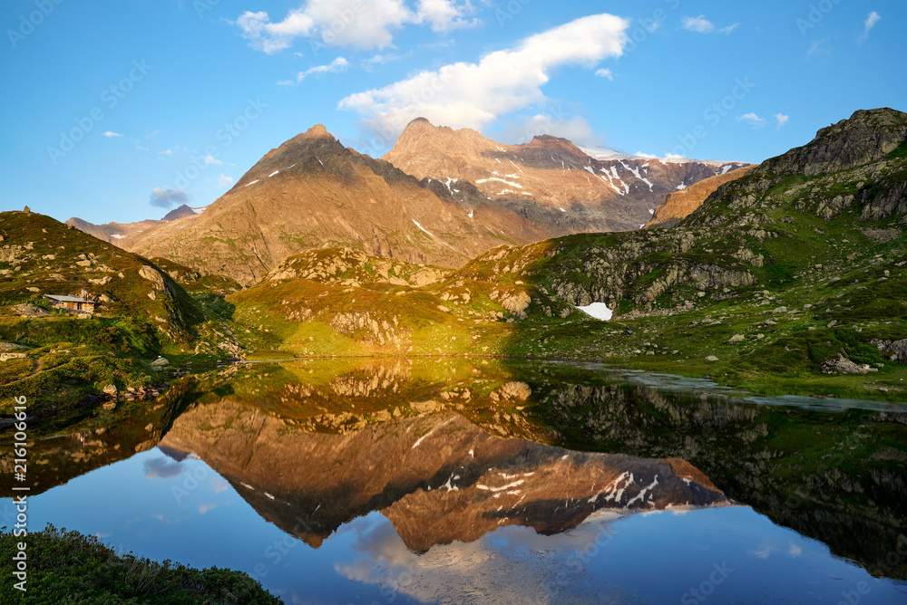 Fototapeta premium Abendsonne, Bergsee Seebodensee, Spiegelung im Wasser, Blick auf Sustenspitz, Chli Sustenhorn, Sustenhorn; Himmel mit Wolken