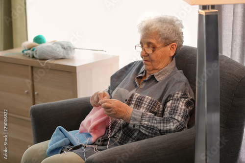 Senior woman sitting on arm...