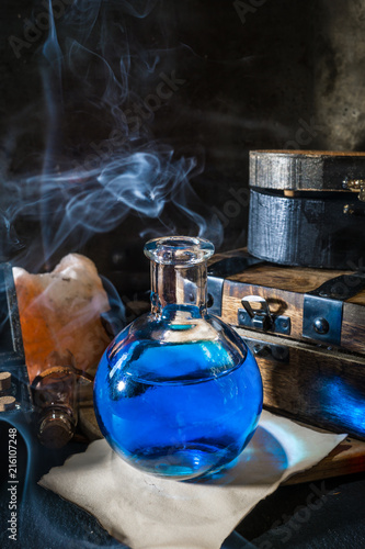 Magic concept. Blue potion in glass bottle