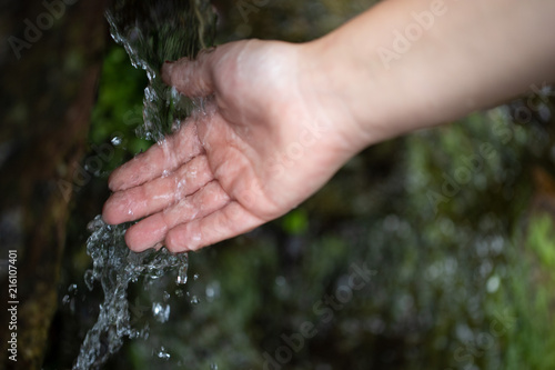 Hand unter kaltem Wasser an einer Quelle