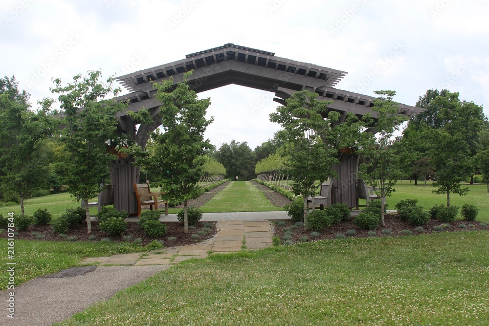 The wooden arch in the parks garden on a cloudy day.