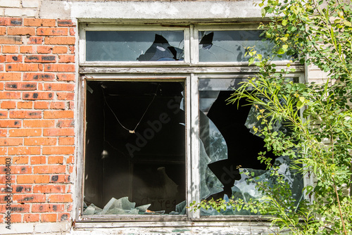 Broken Windows and glass in an old, abandoned brick house photo