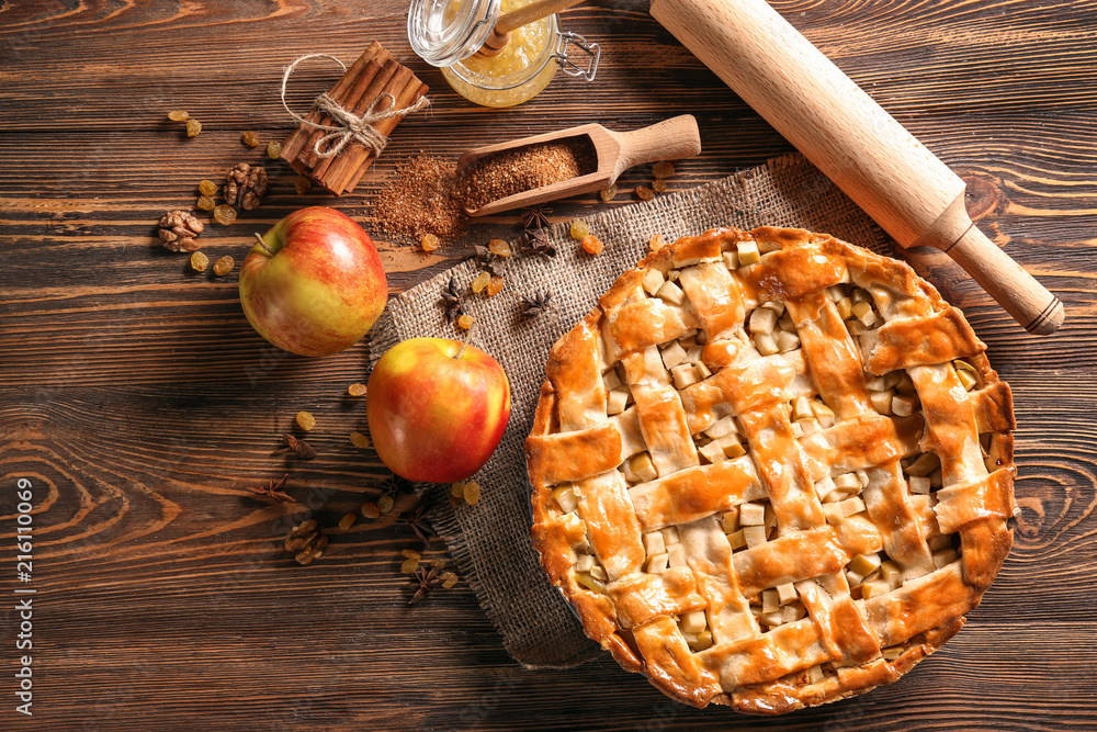 Composition with delicious apple pie on wooden table Composition with delicious apple pie on wooden table
