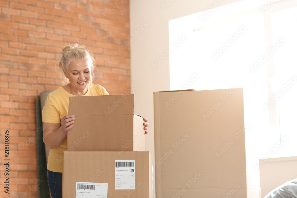 Mature woman with moving boxes at new home Mature woman with moving boxes at new home