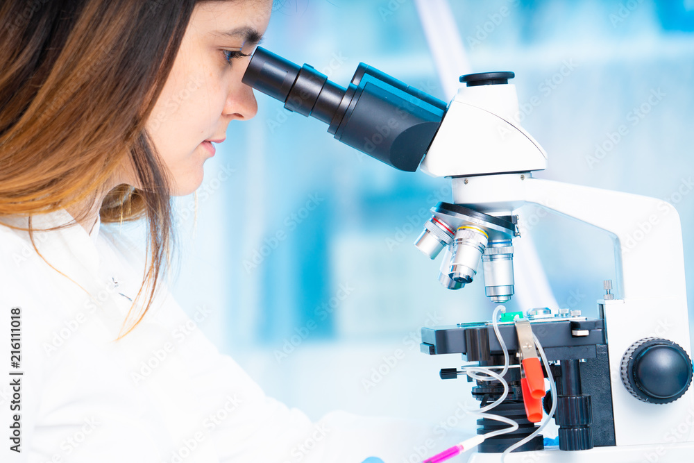 technician girl with microfluidic device LOC in microbiological lab