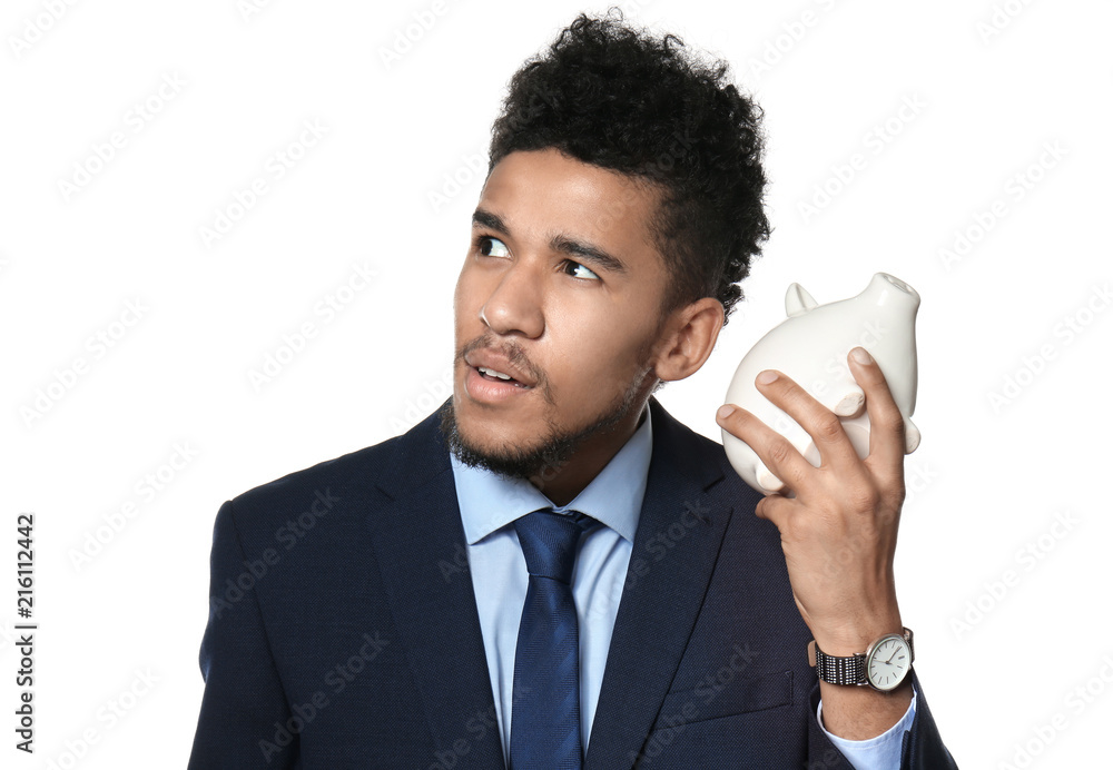 African-American businessman with piggy bank on white background African-American businessman with piggy bank on white background