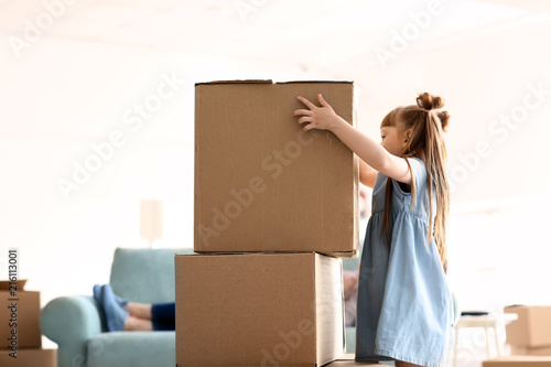 Cute girl stacking cardboar...
