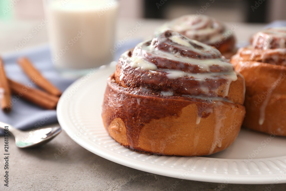 Plate with tasty cinnamon buns on table, closeup Plate with tasty cinnamon buns on table, closeup