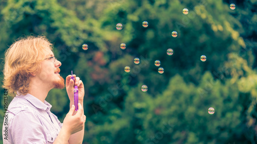 Man blowing soap bubbles outdoor