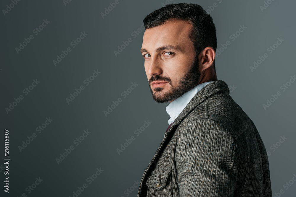 handsome confident man posing in tweed jacket, isolated on grey handsome confident man posing in tweed jacket, isolated on grey