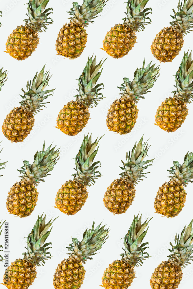 Isolated pineapples pattern or wallpaper on white background. Summer concept of fresh ripe whole pineapples shot from above Isolated pineapples pattern or wallpaper on white background. Summer concept of fresh ripe whole pineapples shot from above