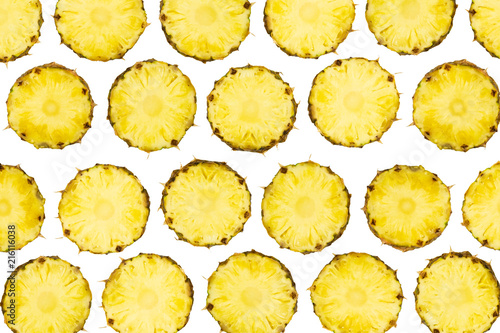 Sliced pineapple pieces lay in pattern on isolated white background.  Freshly cut pineapple fruit