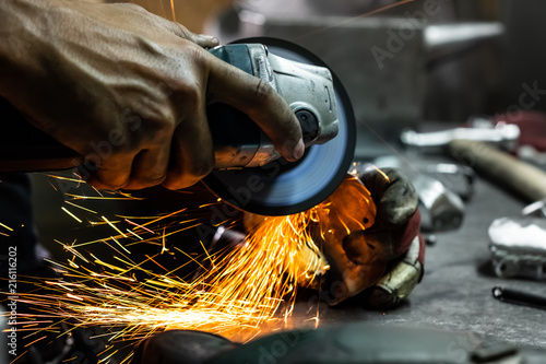 Fotografie Male metal worker polishing and finalising piece of medieval armour suit