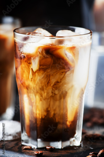 Summer cold coffee with ice and milk, brown background, selective focus and shallow DOF