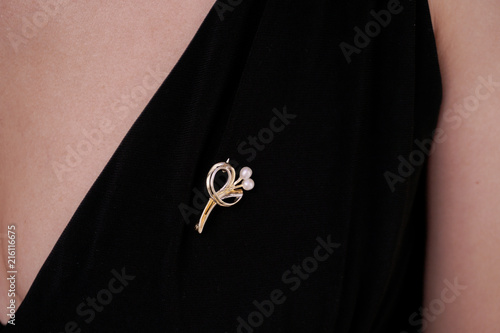 Billede på lærred Woman wearing a golden brooch with a flower