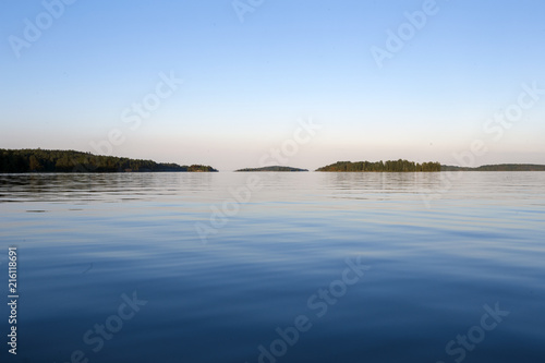 Water surface under the blue sky with Islands on the horizon