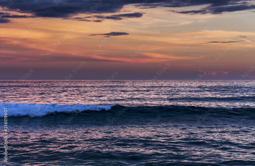 Obraz premium Sunset praia com nuvens alaranjadas