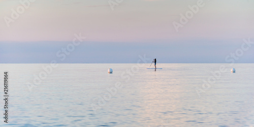 single man on Stand Up Paddle Board. SUP. in beatutiful sunset