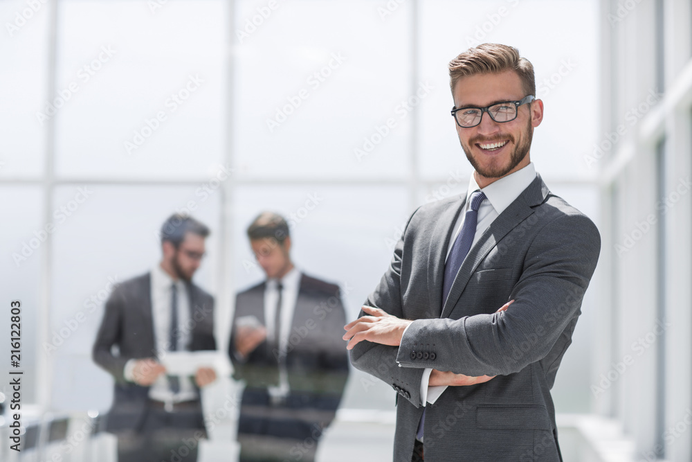 smiling businessman on blurred office background