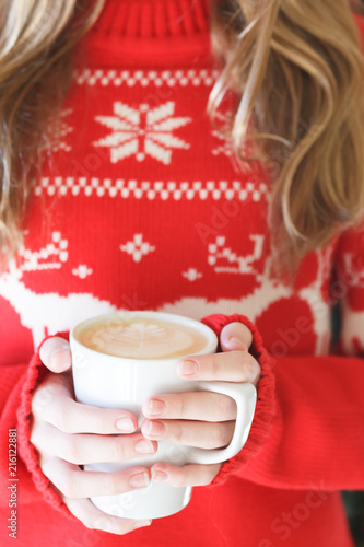 Girl holding a cappuccino cup. Concept of Christmas holiday. Holiday background