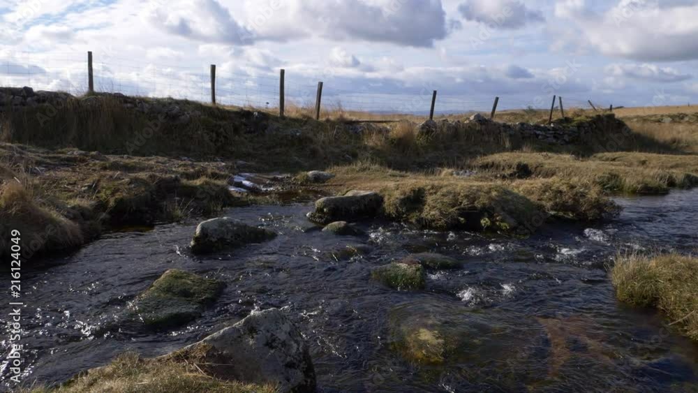 Hilly area with river and rocks in the English countryside of Dartmoor, national park. Slow motion Hilly area with river and rocks in the English countryside of Dartmoor, national park. Slow motion