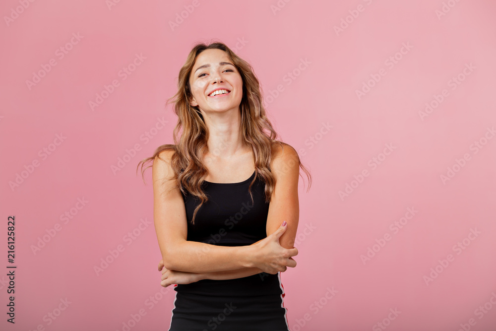 Portrait of young cheerful blonde woman wearing black dress against pink background Portrait of young cheerful blonde woman wearing black dress against pink background