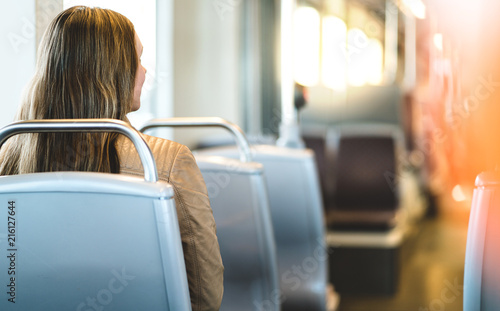 Tela Back view of young woman sitting in public transportation