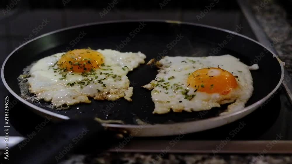 Two eggs being fried on the frying pan Two eggs being fried on the frying pan